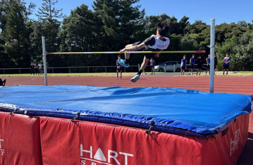 Young athlete jumps over bar in high jump event