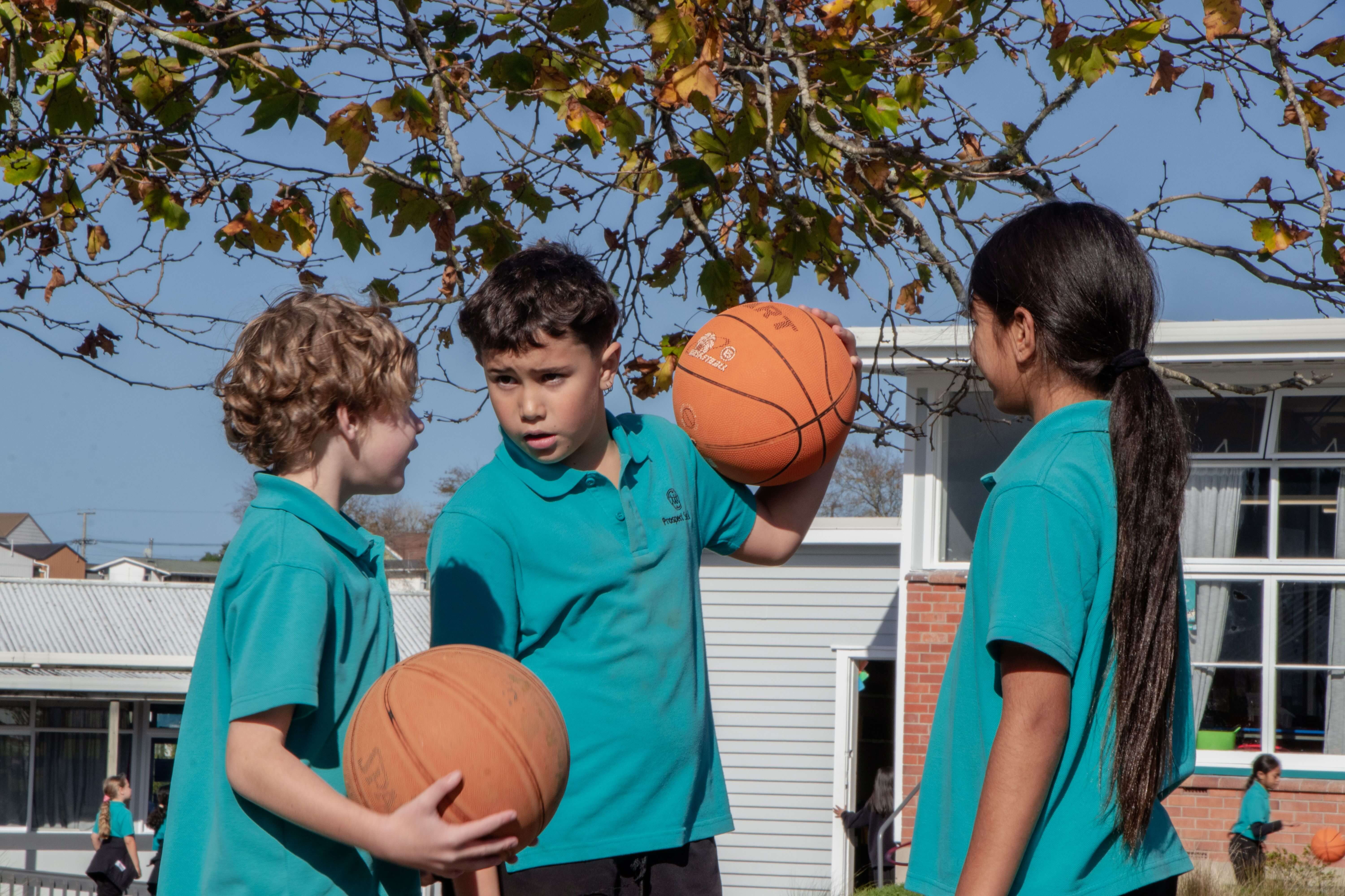 Tamariki playing basketball